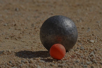 Petanque ball with an orange bowling pin