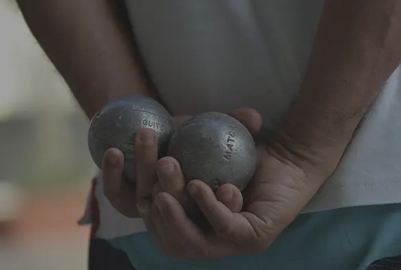 Petanque player holding the balls